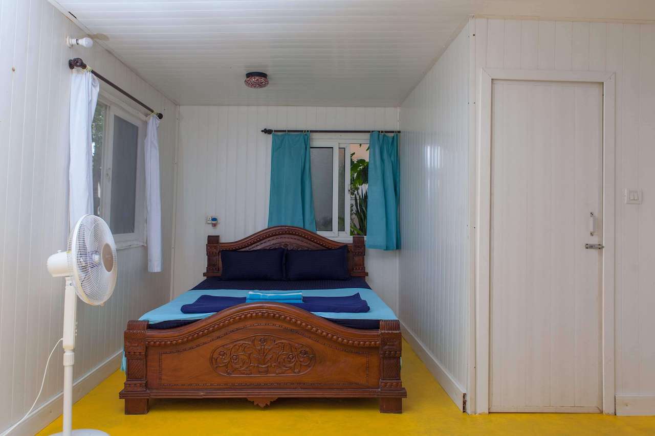 A comfortable bed in a clean and cosy room welcomes travelers and surfers in the beachside guesthouse